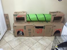 there is a cat in a cardboard box on top of the dog house that's built into the floor