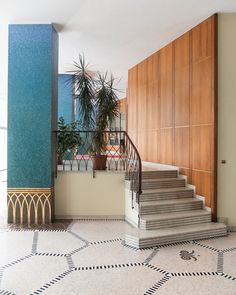 a staircase in an apartment with tiled flooring and wooden paneling on the walls