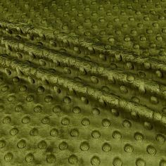 a close up image of a green fabric with small circles on the top and bottom