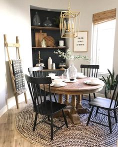 a dining room table and chairs in front of a book shelf with books on it