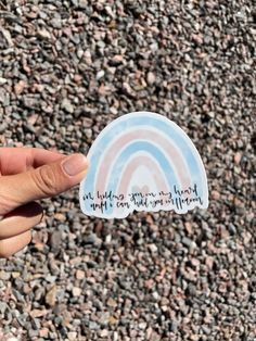 someone is holding up a sticker with a rainbow in the middle and words on it