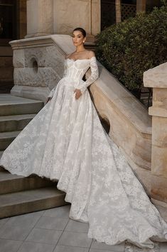 a woman in a wedding dress standing on some steps with her hand on her hip