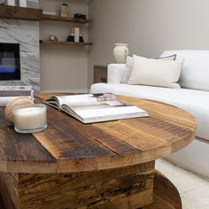 a living room with a couch, coffee table and book on the end of it