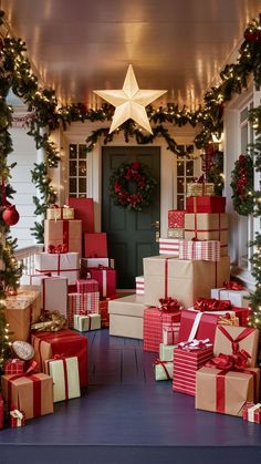 christmas presents are piled up in front of a door with garland and wreaths on it