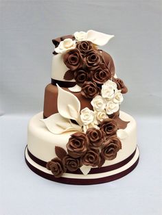 a three tiered cake decorated with chocolate and white flowers