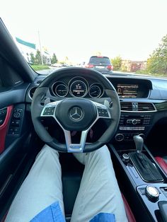 someone is sitting in the driver's seat of a car with their feet on the steering wheel