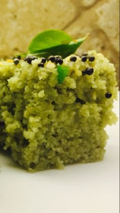 a piece of green cake with blackberries on top