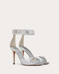 Valentino Garavani VLogo Locker sandal in mirrored calfskin - VLogo Signature swivel closure straps in tone-on-tone finish - Heel height: 105 mm / 4.2 in. - Made in Italy Luxury Silver Heels With Buckle Closure, Luxury Open Heel Heels With Buckle Closure, Luxury Ankle Strap Heels For Gala, Luxury Patent Leather Heels With Buckle Closure, Luxury Evening Sandals With Buckle Closure, Luxury Patent Leather Sandals With Sculpted Heel, Luxury Sandals With Sculpted Heel In Patent Leather, Luxury Sandals With Sculpted Heel, Luxury Buckle Closure Sandals For Gala