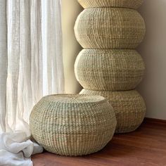 three wicker stools stacked on top of each other in front of a window