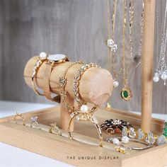 an assortment of jewelry is displayed on a wooden stand