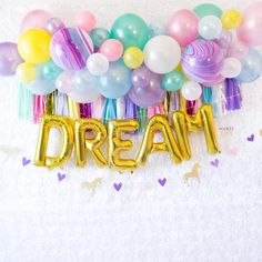 balloons and streamers with the word dream written in gold