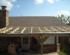 a house that is being built with wood framing on the roof and covered in shingles