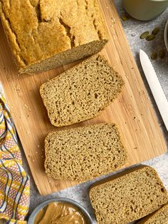 slices of bread sitting on top of a wooden cutting board next to bowls of peanut butter