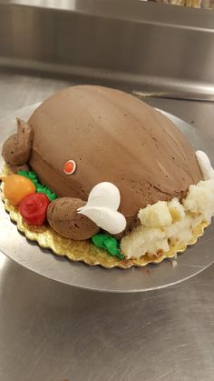 there is a cake that looks like an animal on top of some ice cream and carrots