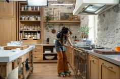 a woman standing in a kitchen preparing food