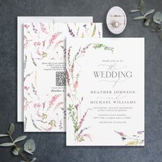 the wedding stationery is laid out on a table next to some flowers and greenery