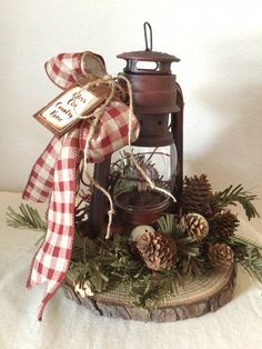 an old fashioned lantern with pine cones and other decorations