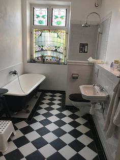 a black and white checkered floor in a bathroom with a claw foot bathtub