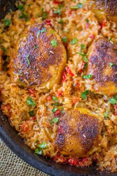 chicken and rice dish in a skillet on a table with a cloth under it