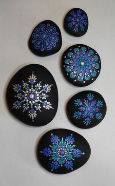 four painted rocks sitting on top of a white table