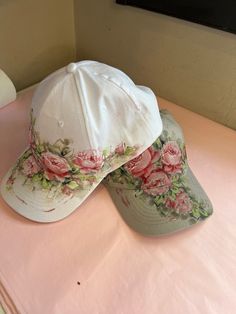 two hats sitting on top of a pink table