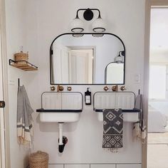 a bathroom with two sinks and a mirror on the wall above it is decorated in black and white