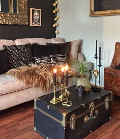 a living room filled with furniture and candles on top of a table next to a couch