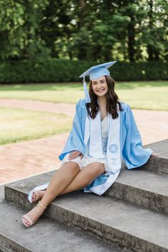 a woman sitting on the steps in her graduation gown