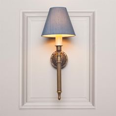 a wall lamp with a blue shade on it's side in a white room