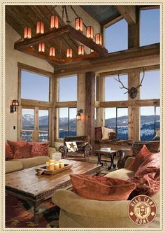 a living room filled with lots of furniture and large windows covered in wood planks