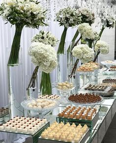 an assortment of desserts and pastries displayed in glass vases on a table