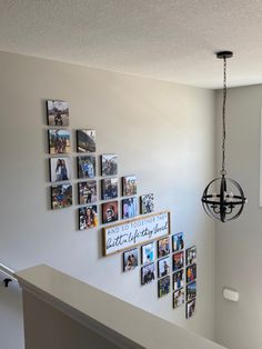 a white wall with pictures on it and a chandelier hanging from the ceiling