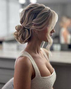 a woman with blonde hair wearing a white dress in a kitchen looking off to the side