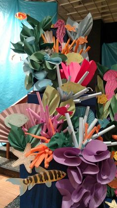 an arrangement of colorful paper flowers in a vase