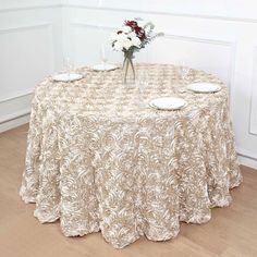 a table topped with two plates and a vase filled with flowers on top of it