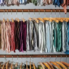 many different colored shirts are hanging on the rack