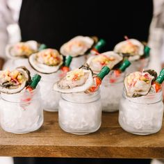 a person holding a tray with some food in small cups on it and other items