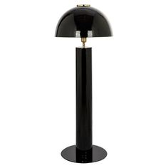 a black table lamp with a gold base and an oval shade on the top, in front of a white background