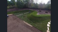 an aerial view of a golf course in the middle of a park with people on it