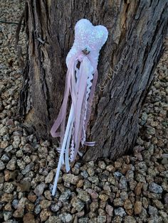 a pink and white ribbon tied to a tree