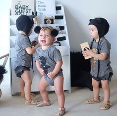 three young children standing in front of a book shelf