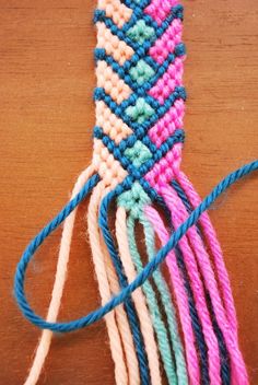 several different colored ropes on top of a wooden table