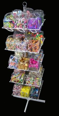 a stack of plastic containers filled with candy and candies on top of a black background