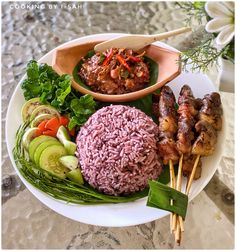 a white plate topped with meat and veggies on top of a marble table