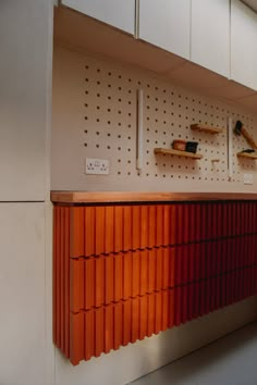 an orange shelf with several different items on it's sides and some shelves behind it