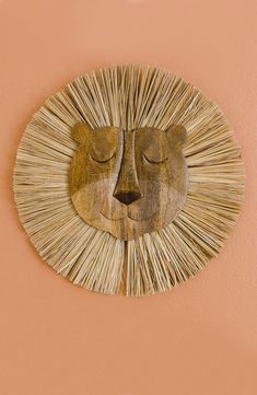 a wall hanging with a face made out of straw