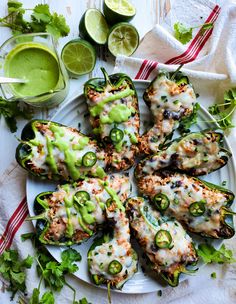 mexican style stuffed peppers on a plate with limes and cilantro garnishes