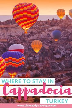 hot air balloons flying in the sky with text where to stay in cappadocia turkey