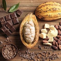 some nuts, chocolate and other food on a wooden table with green leafy leaves