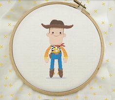 a cross stitch pattern with a cartoon character in a cowboy hat and blue jeans, on a white background